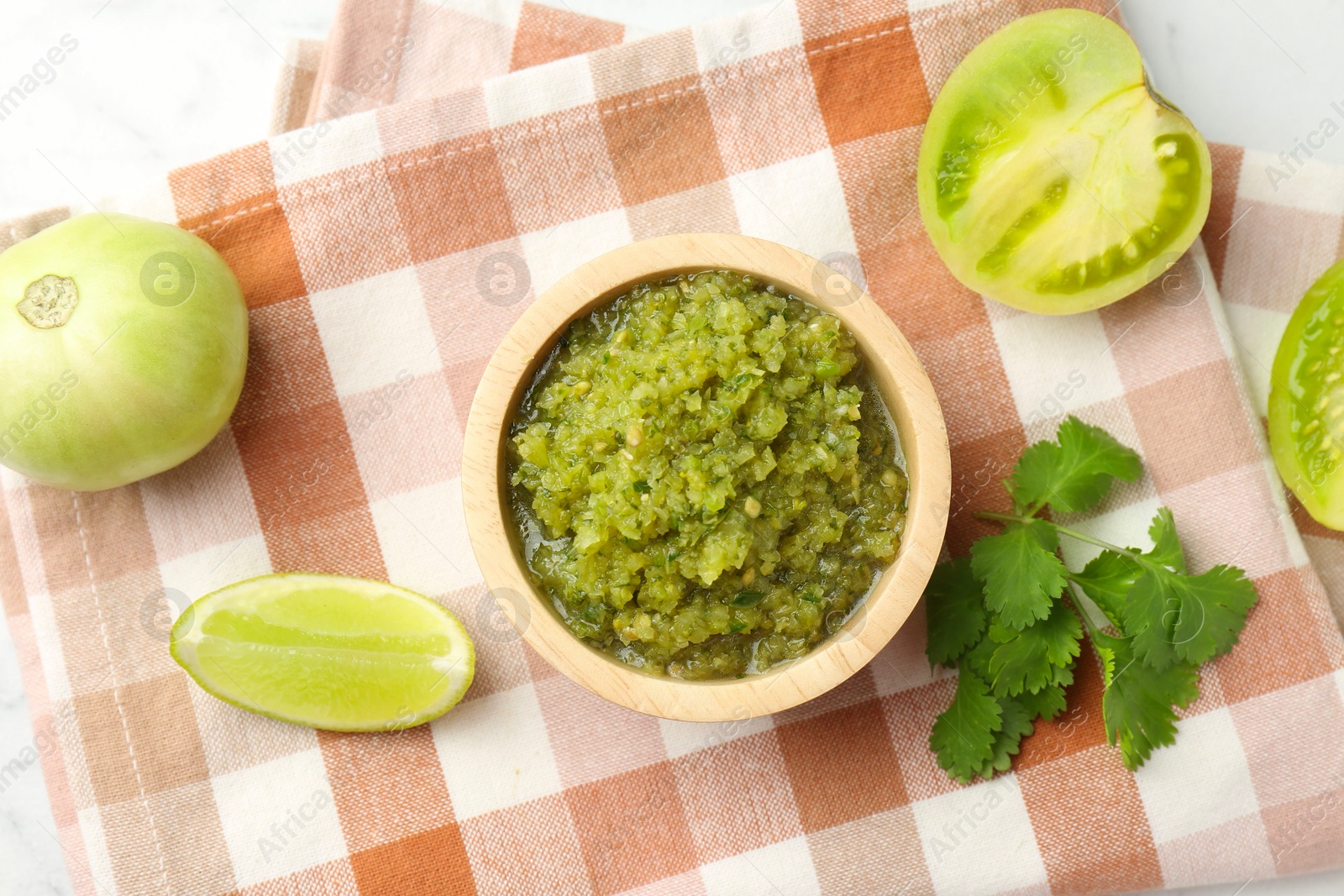 Photo of Spicy salsa and ingredients on white table, flat lay