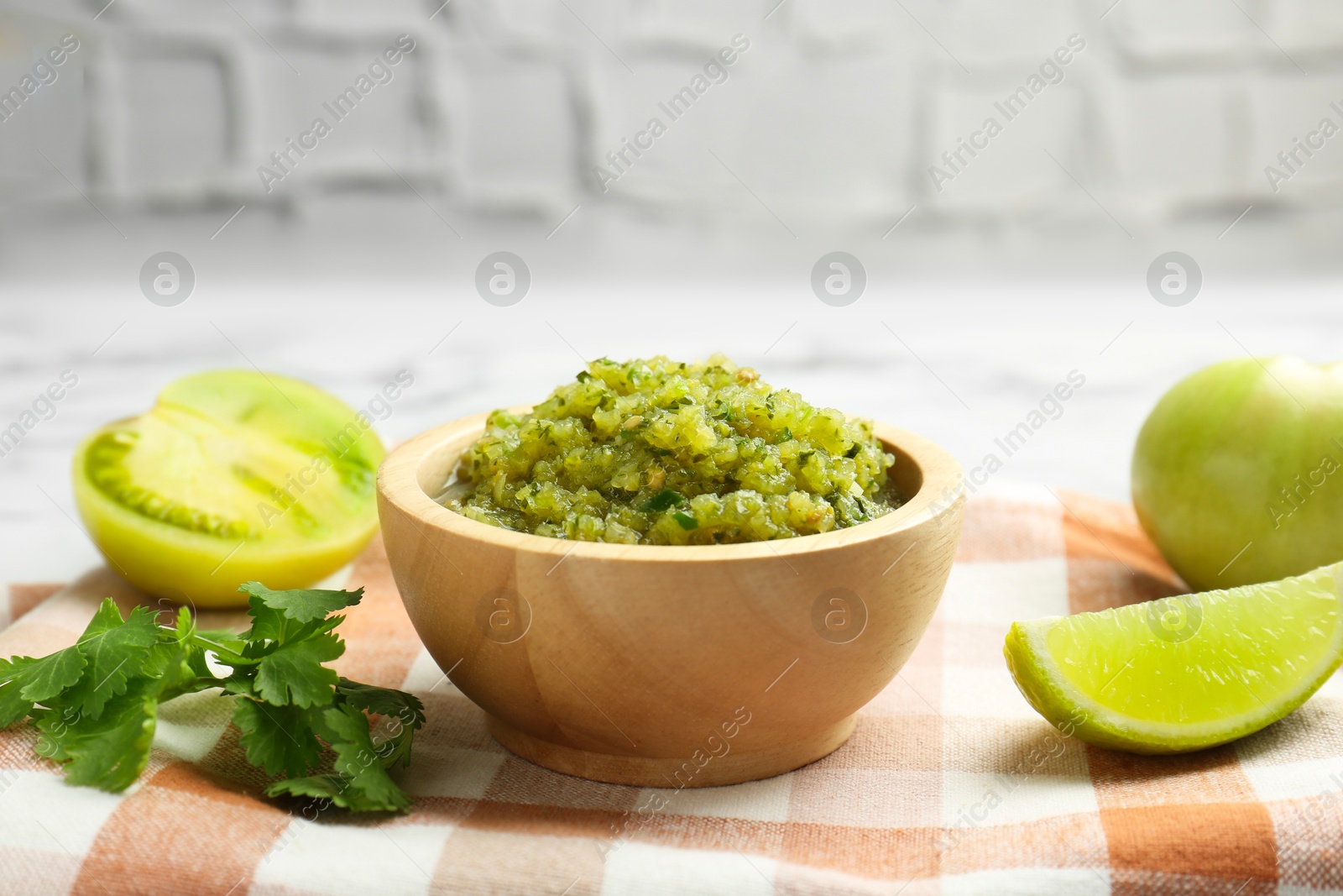 Photo of Spicy salsa and ingredients on table, closeup