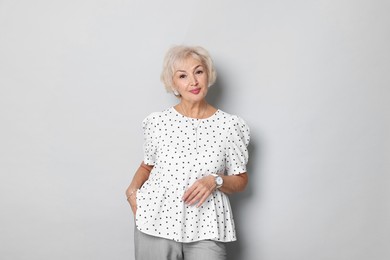 Portrait of elegant grandmother on light grey background