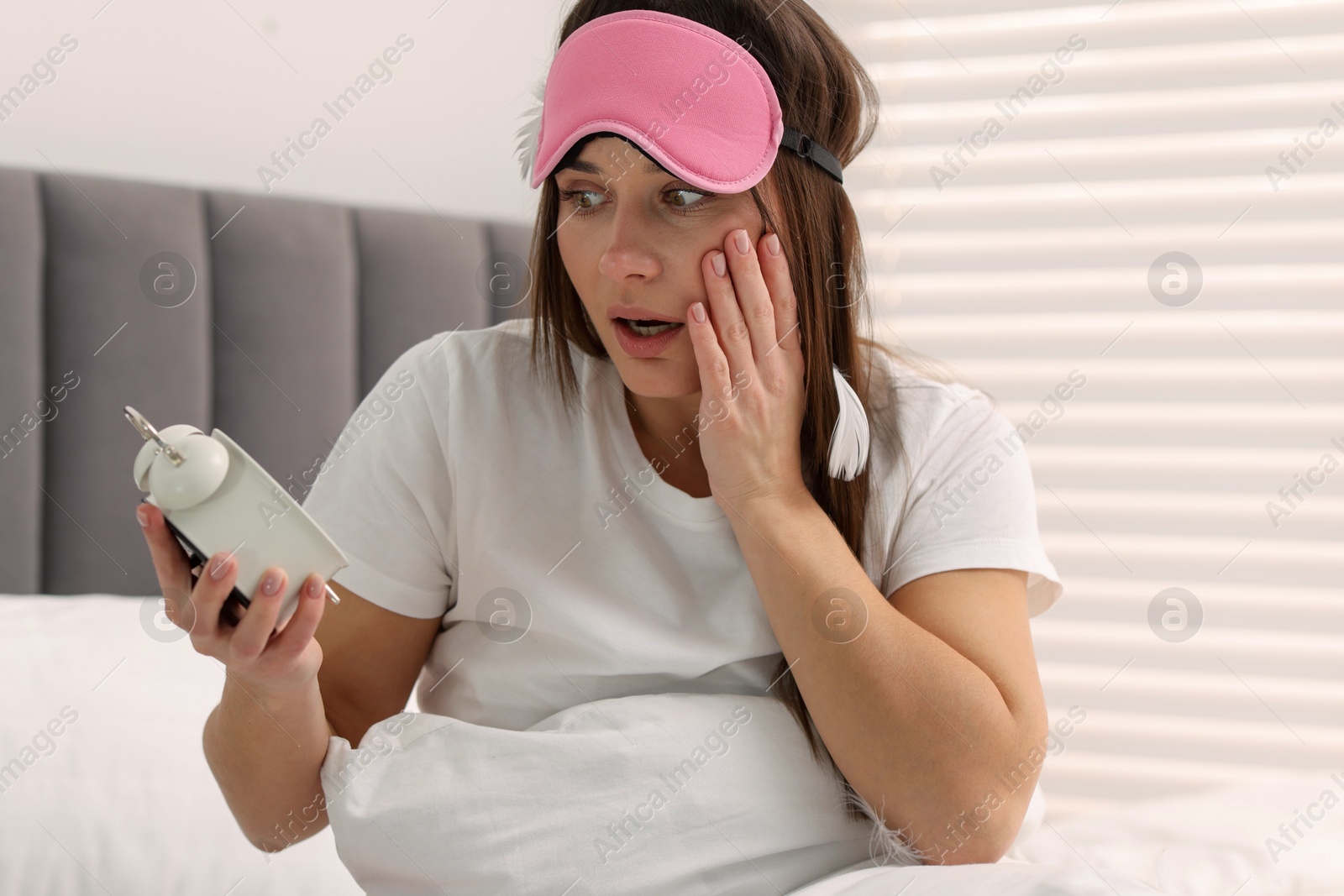 Photo of Overslept woman with alarm clock in bed at home