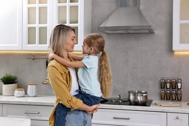 Happy housewife and her daughter cooking and spending time together in kitchen