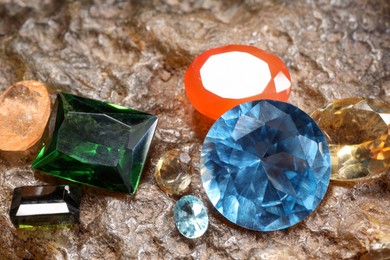 Photo of Beautiful shiny colorful gemstones on rock, closeup