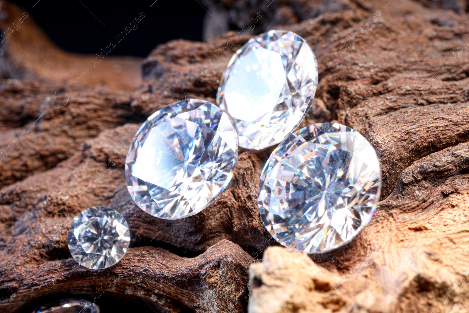 Photo of Beautiful shiny gemstones on stone, closeup view