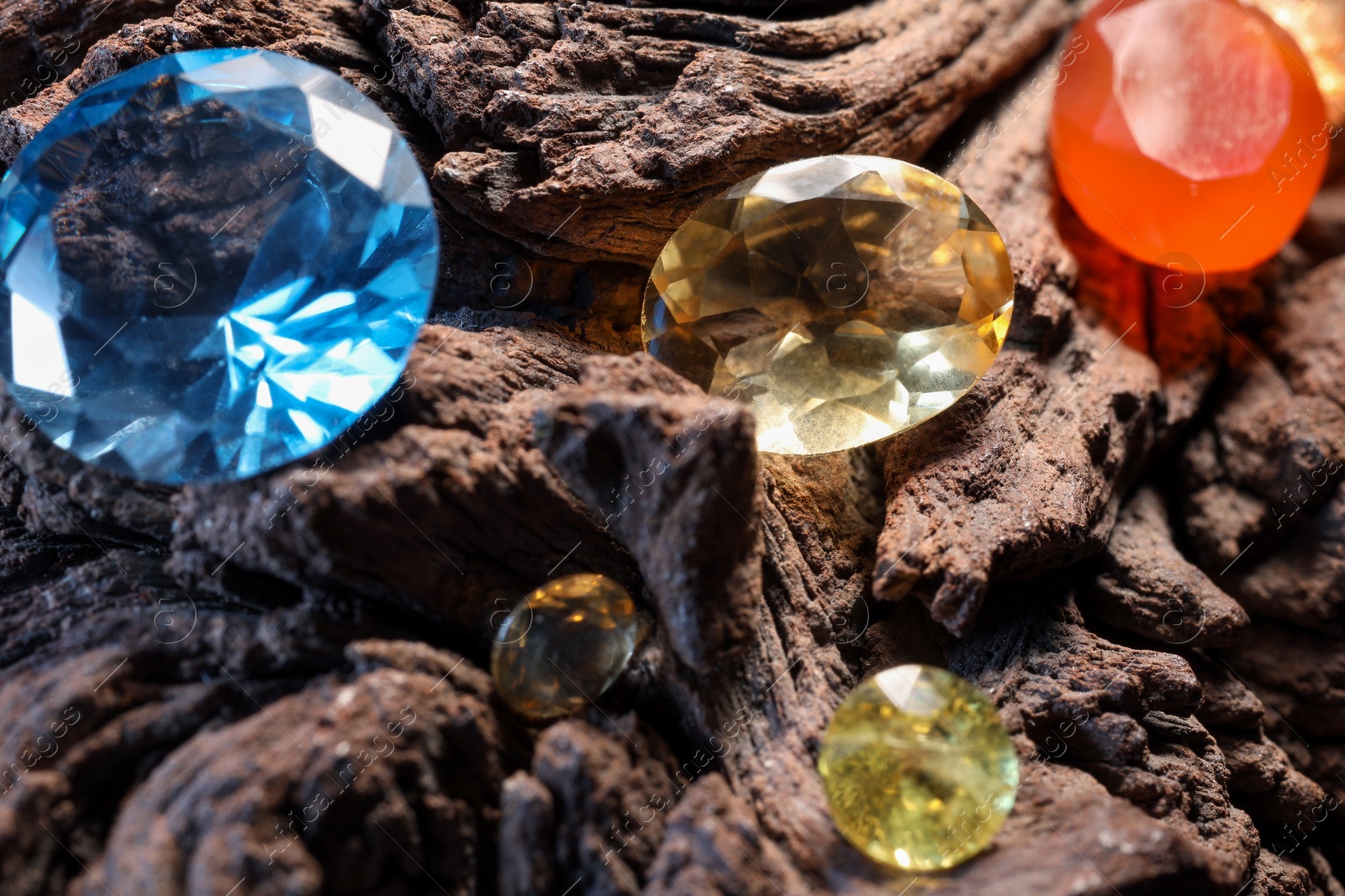 Photo of Beautiful shiny colorful gemstones on stone, closeup