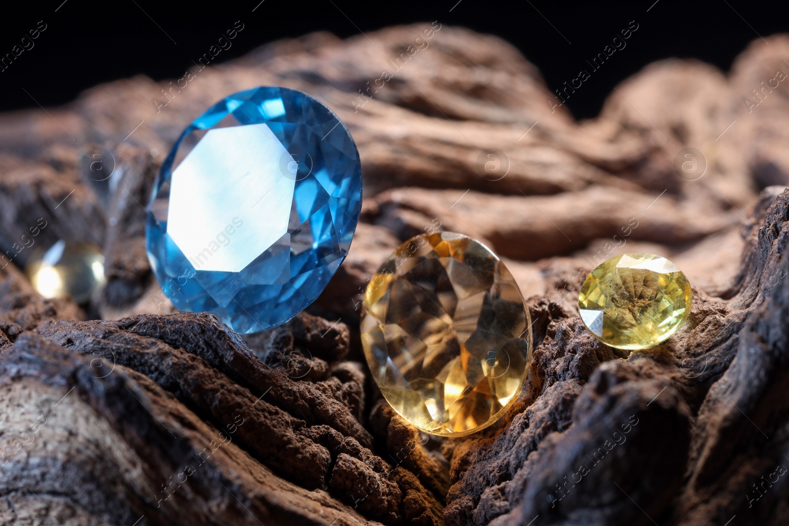 Photo of Beautiful shiny colorful gemstones on stone, closeup