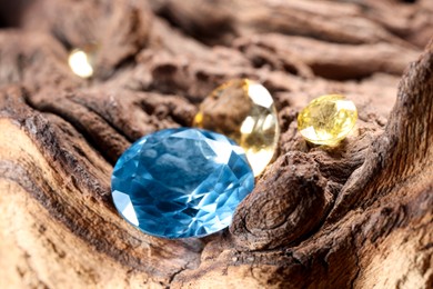 Photo of Beautiful shiny colorful gemstones on stone, closeup