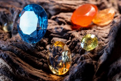 Photo of Beautiful shiny colorful gemstones on stone, closeup