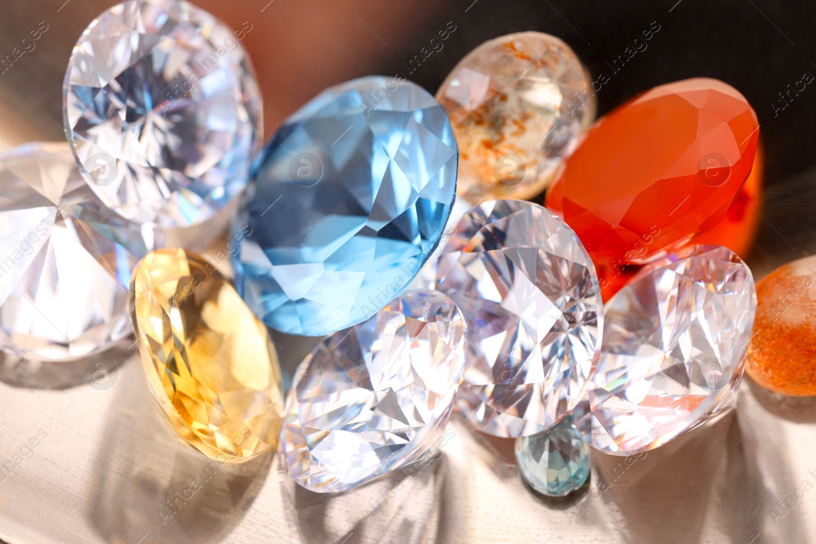 Photo of Beautiful shiny colorful gemstones on light background, closeup