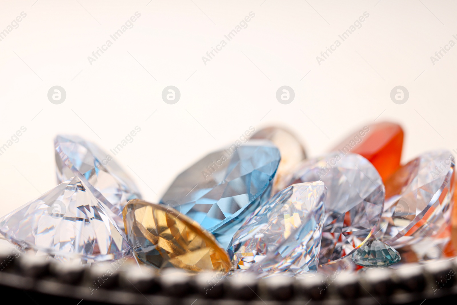 Photo of Beautiful shiny colorful gemstones on light background, closeup