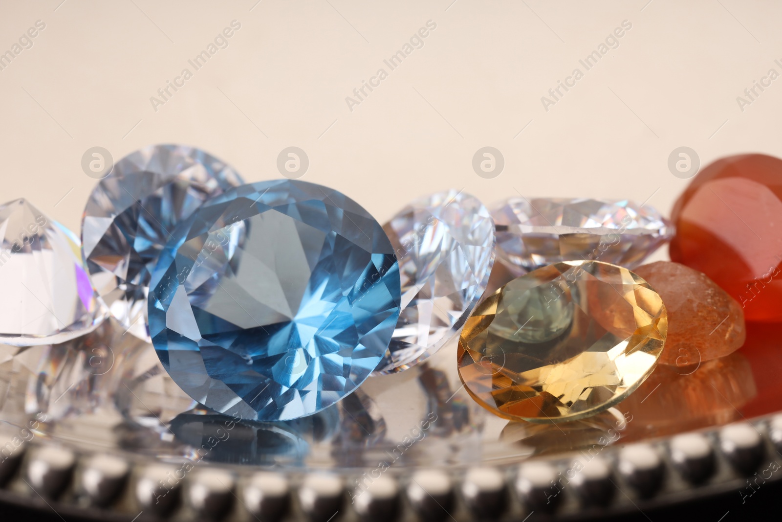 Photo of Beautiful shiny colorful gemstones on light background, closeup