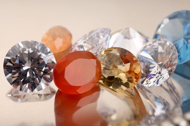 Photo of Beautiful shiny colorful gemstones on light background, closeup