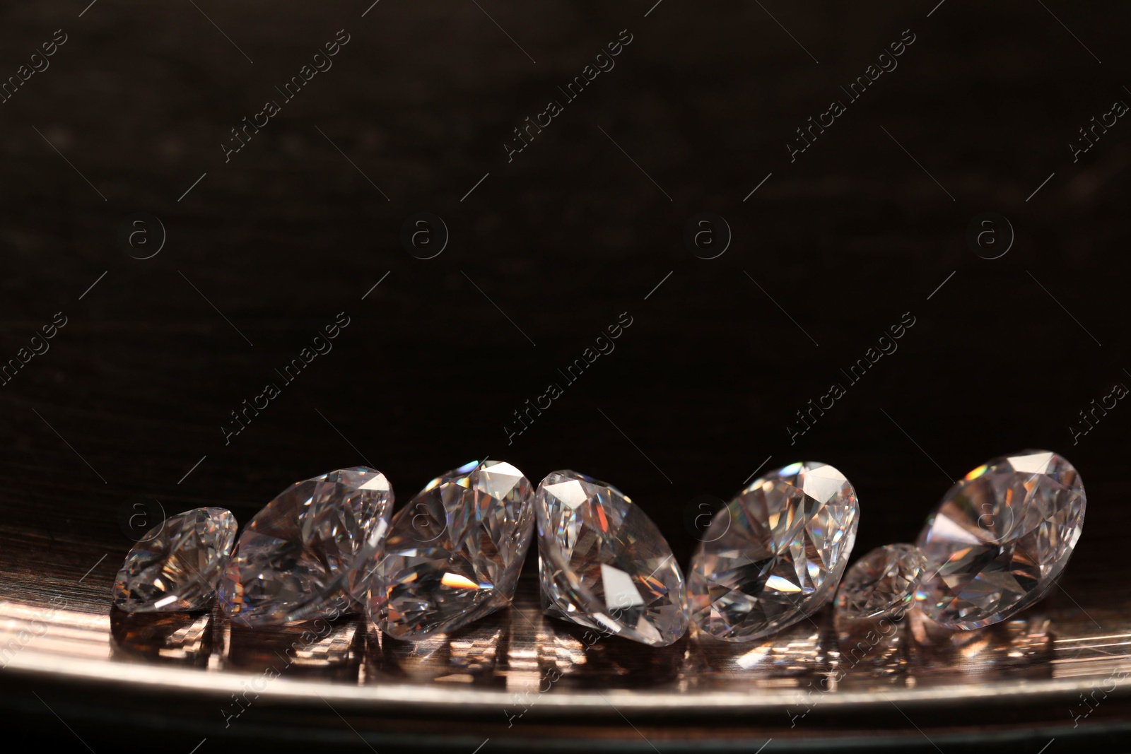 Photo of Beautiful shiny gemstones on metal tray. Space for text