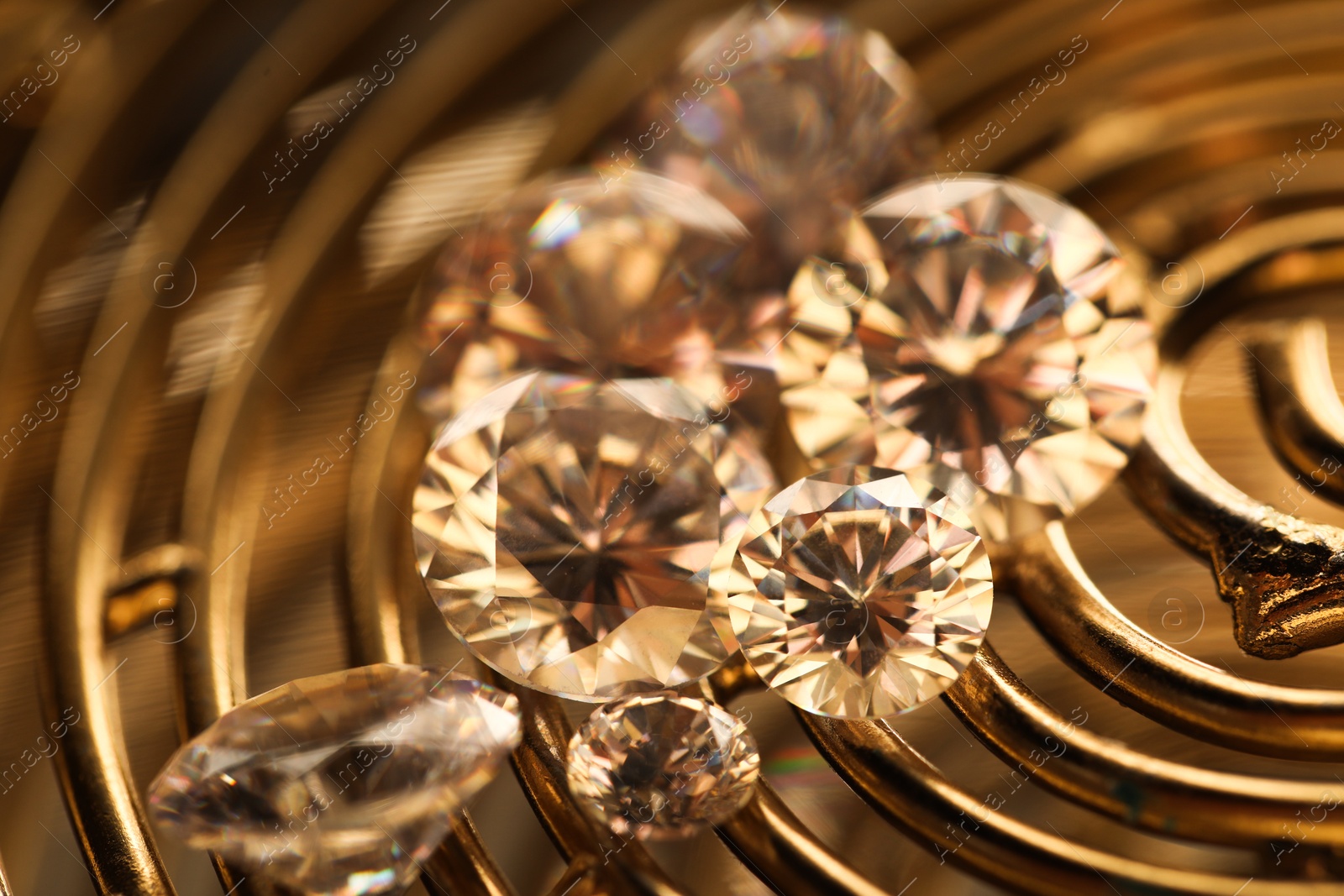 Photo of Beautiful shiny gemstones on golden tray, closeup