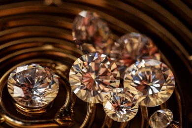 Photo of Beautiful shiny gemstones on golden tray, closeup