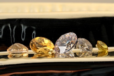 Photo of Beautiful shiny gemstones on light background, closeup