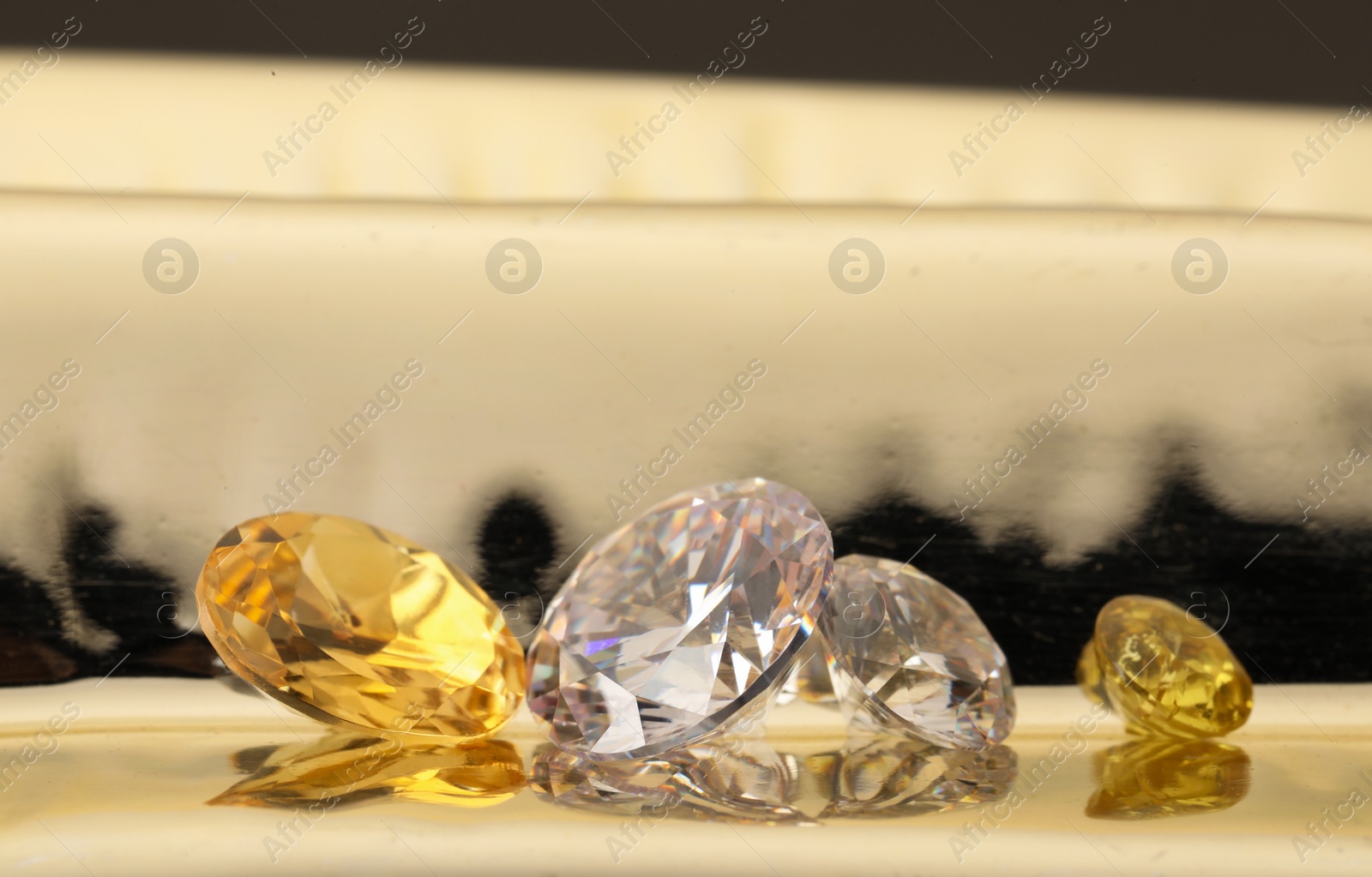 Photo of Beautiful shiny gemstones on light background, closeup