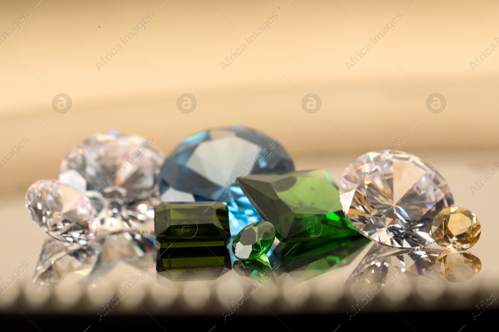 Photo of Beautiful shiny colorful gemstones on light background, closeup