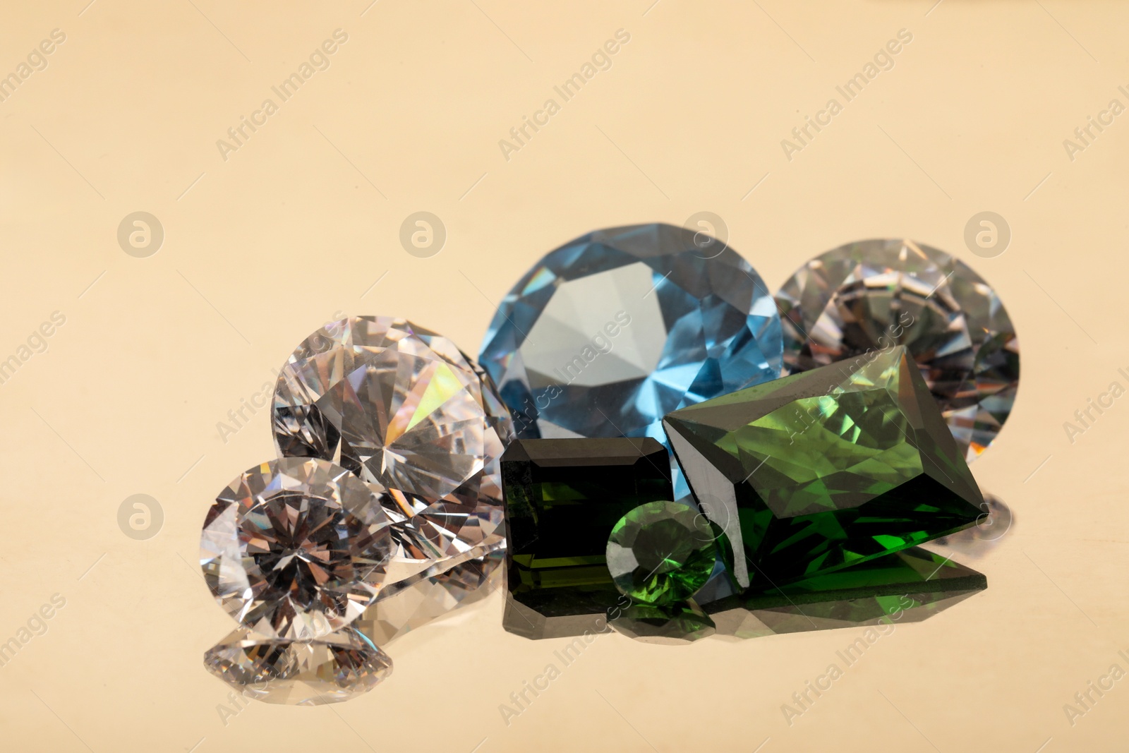 Photo of Beautiful shiny colorful gemstones on light background, closeup