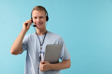 Photo of Technical support call center. Smiling operator with laptop on light blue background. Space for text