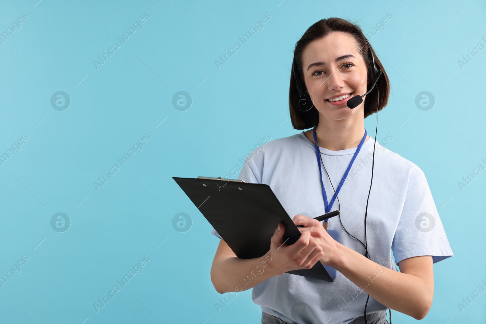 Photo of Technical support call center. Smiling operator with clipboard on light blue background. Space for text