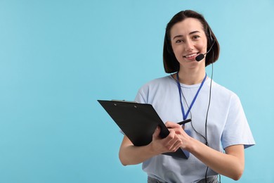 Photo of Technical support call center. Smiling operator with clipboard on light blue background. Space for text