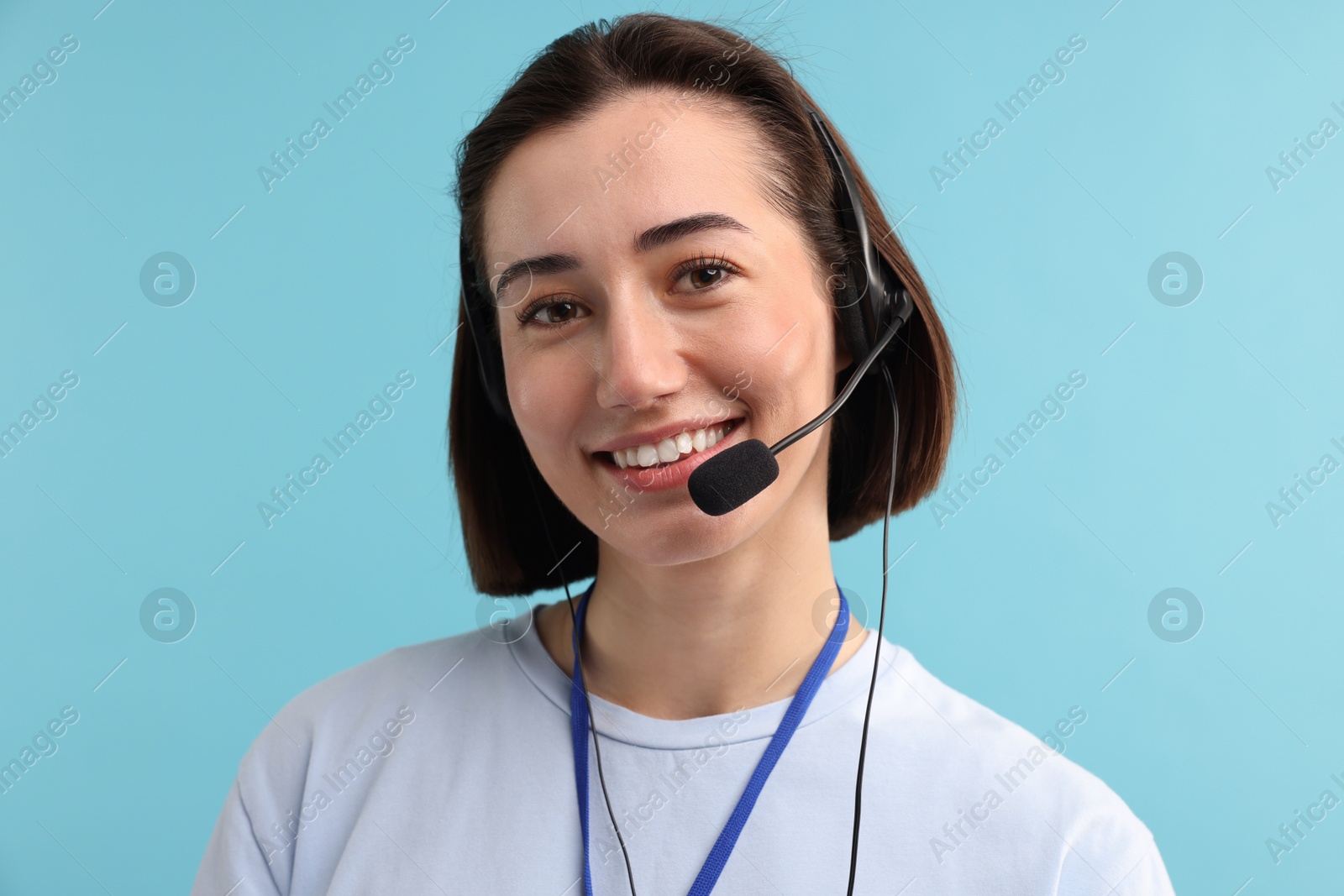 Photo of Technical support call center. Portrait of smiling operator on light blue background