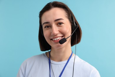 Photo of Technical support call center. Portrait of smiling operator on light blue background