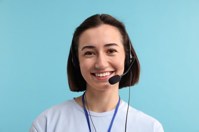 Technical support call center. Portrait of smiling operator on light blue background