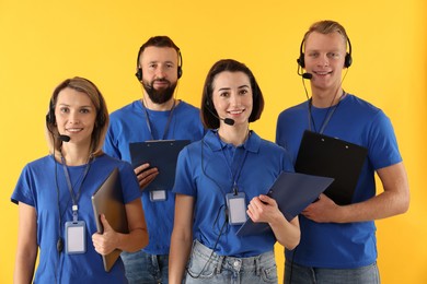 Technical support call center. Team of friendly operators on yellow background