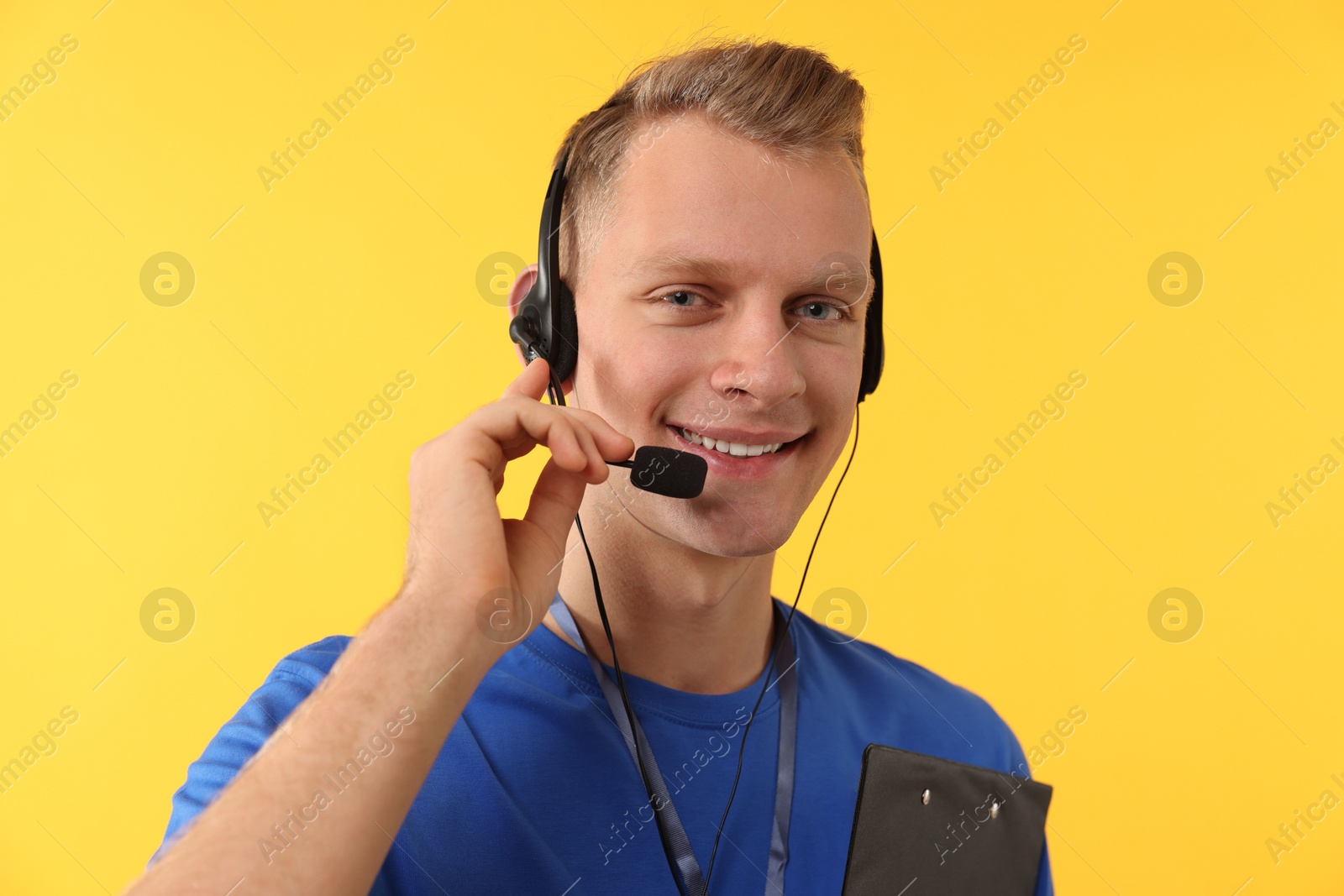 Photo of Technical support call center. Portrait of smiling operator on yellow background