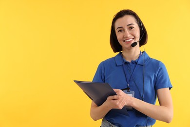 Photo of Technical support call center. Smiling operator with folder on yellow background. Space for text