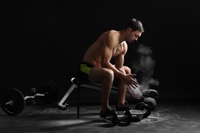 Photo of Man clapping hands with talcum powder before training on black background