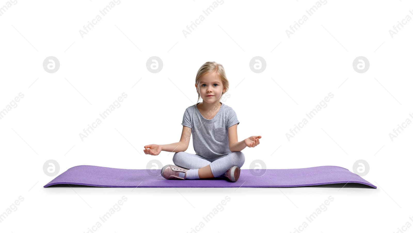 Photo of Little girl exercising on fitness mat against white background. Sport activity