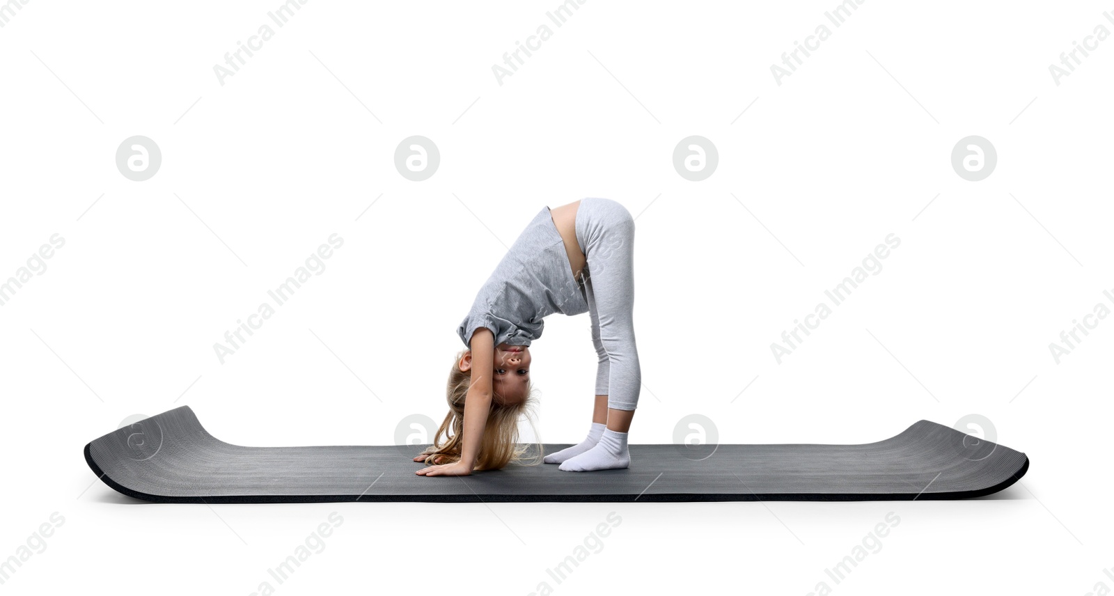 Photo of Little girl exercising on fitness mat against white background. Sport activity