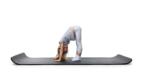 Photo of Little girl exercising on fitness mat against white background. Sport activity