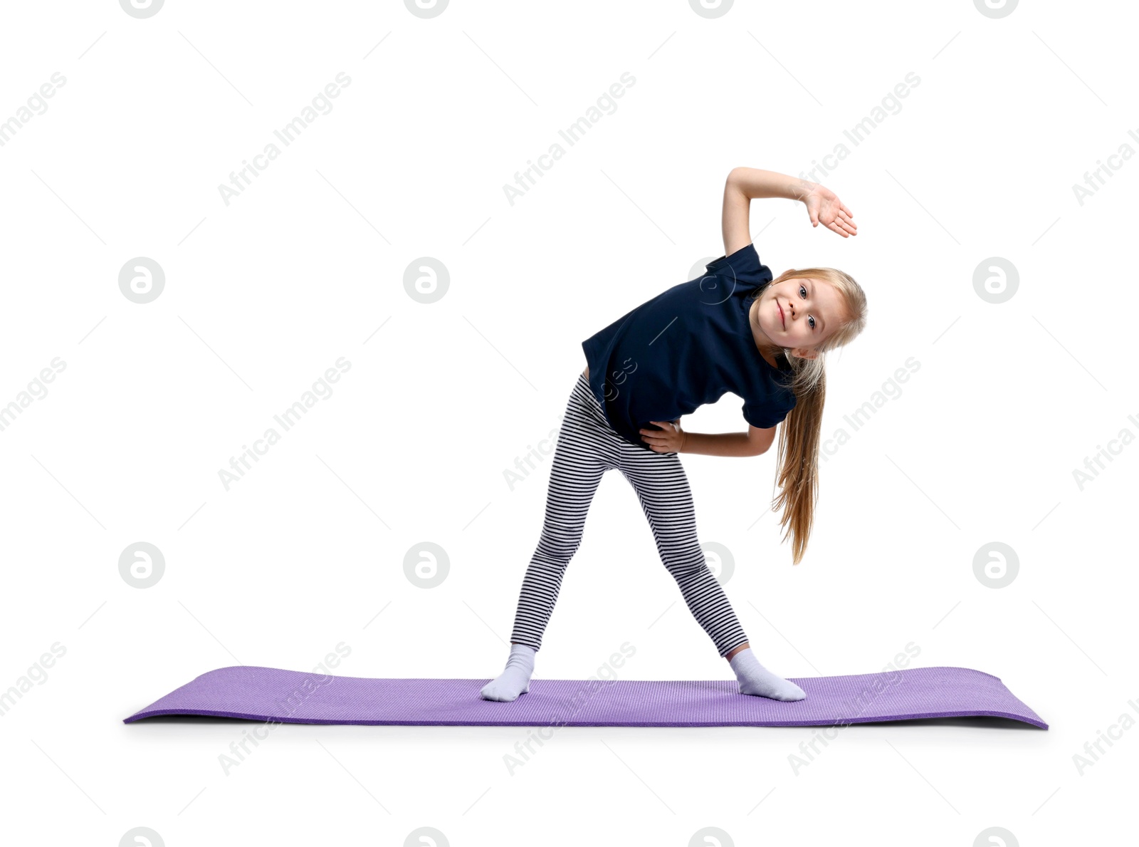 Photo of Little girl exercising on fitness mat against white background. Sport activity