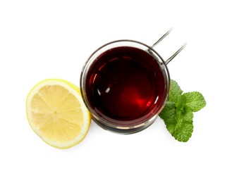 Photo of Glass of aromatic tea in holder, lemon and mint isolated on white, top view