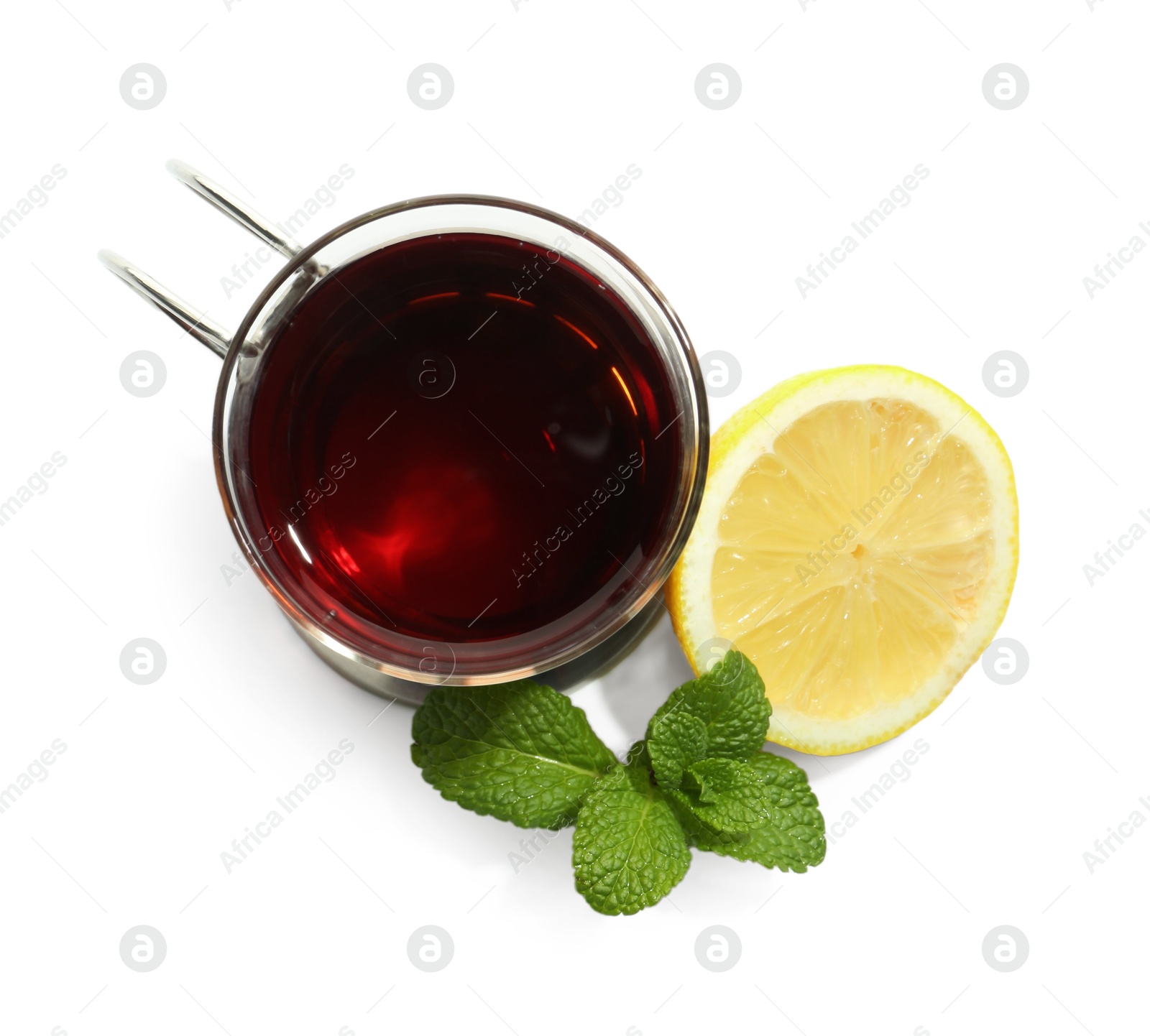 Photo of Glass of aromatic tea in holder, lemon and mint isolated on white, top view