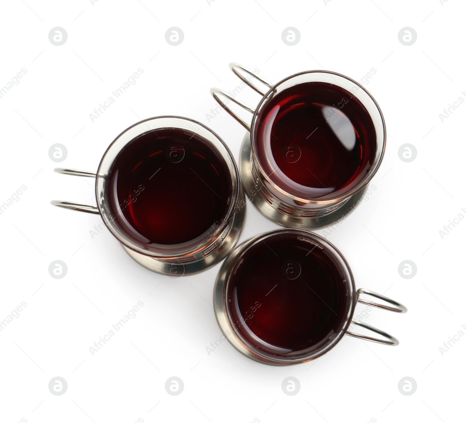 Photo of Glasses of aromatic tea in holders isolated on white, top view