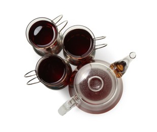 Photo of Glasses of aromatic tea in holders and teapot isolated on white, top view