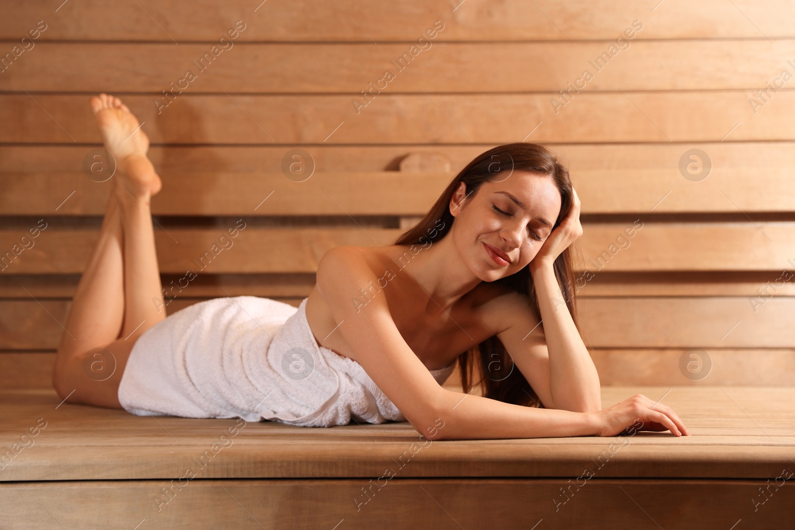 Photo of Beautiful woman relaxing on bench at sauna