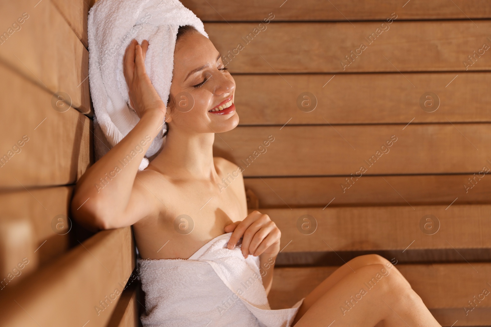 Photo of Smiling woman relaxing at sauna. Space for text