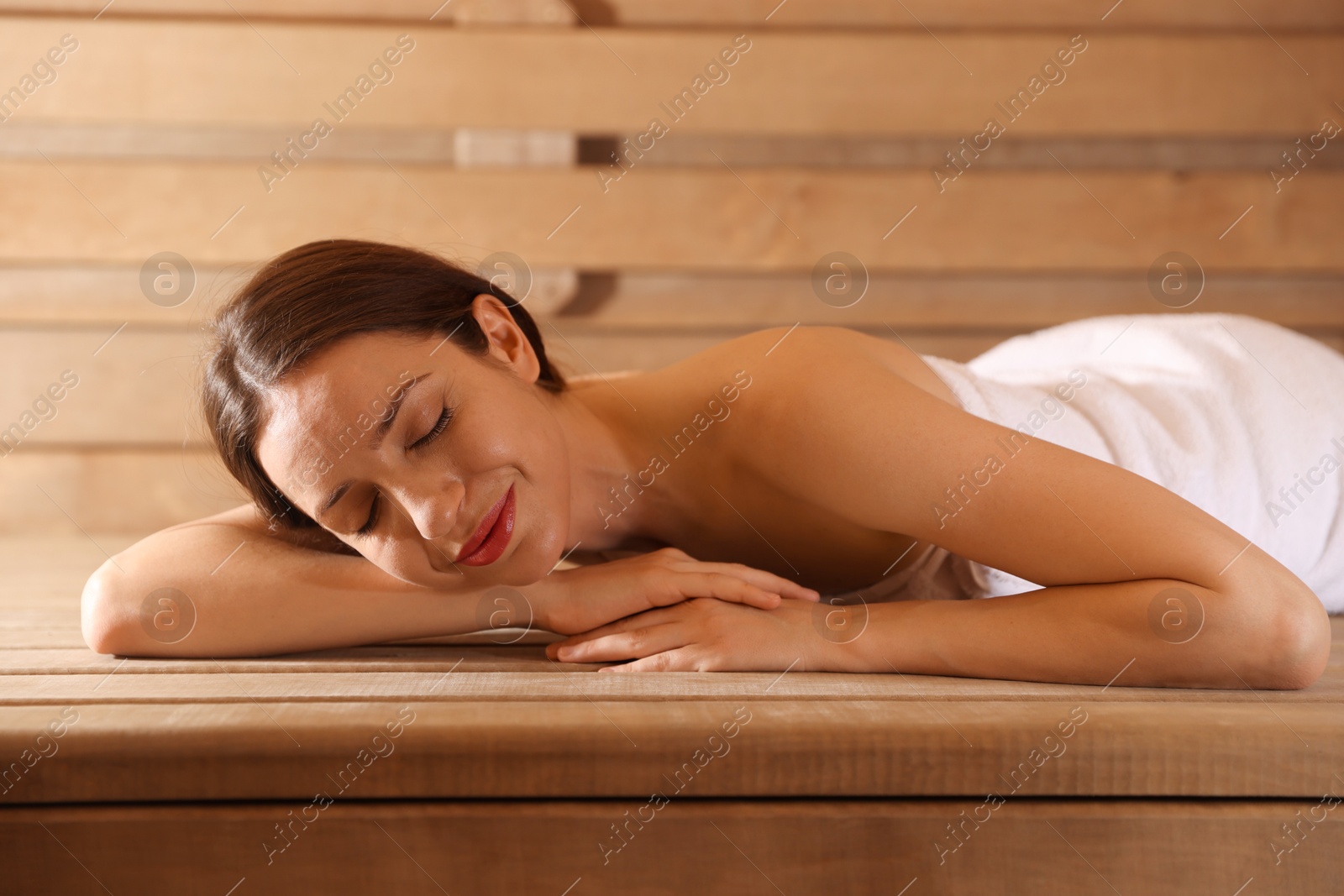 Photo of Beautiful woman relaxing on bench at sauna