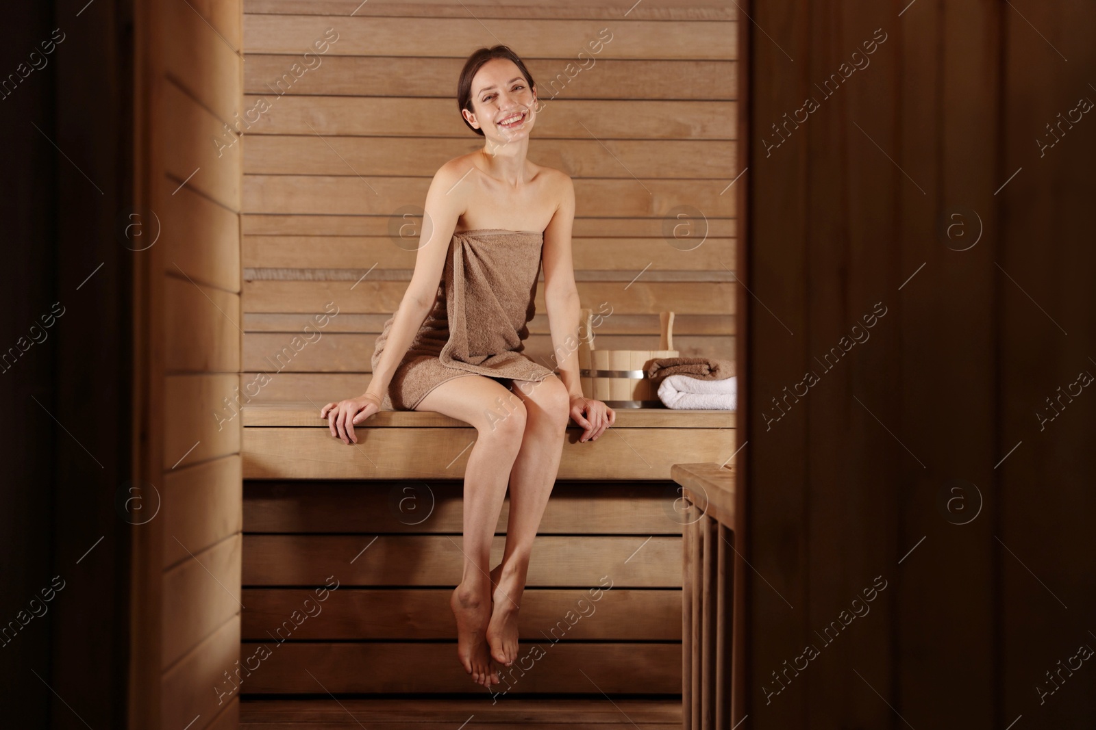 Photo of Smiling woman sitting on bench at sauna