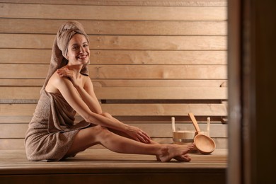 Photo of Smiling woman relaxing on bench at sauna. Space for text