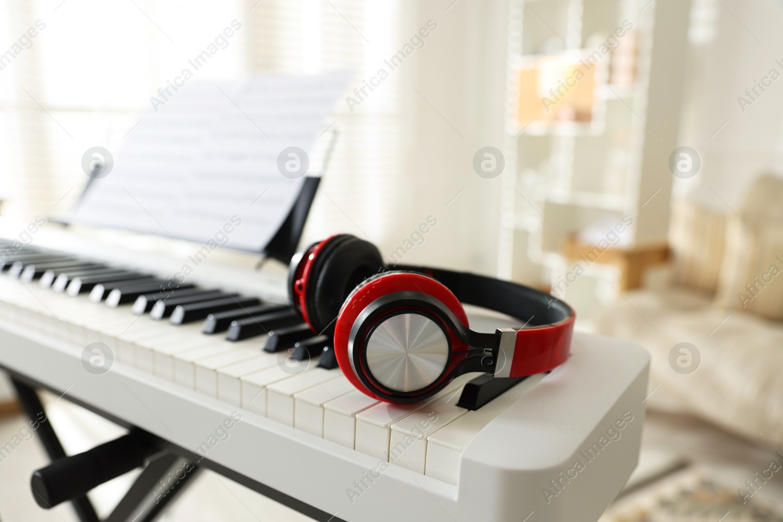 Photo of Synthesizer with music sheets and headphones indoors, closeup