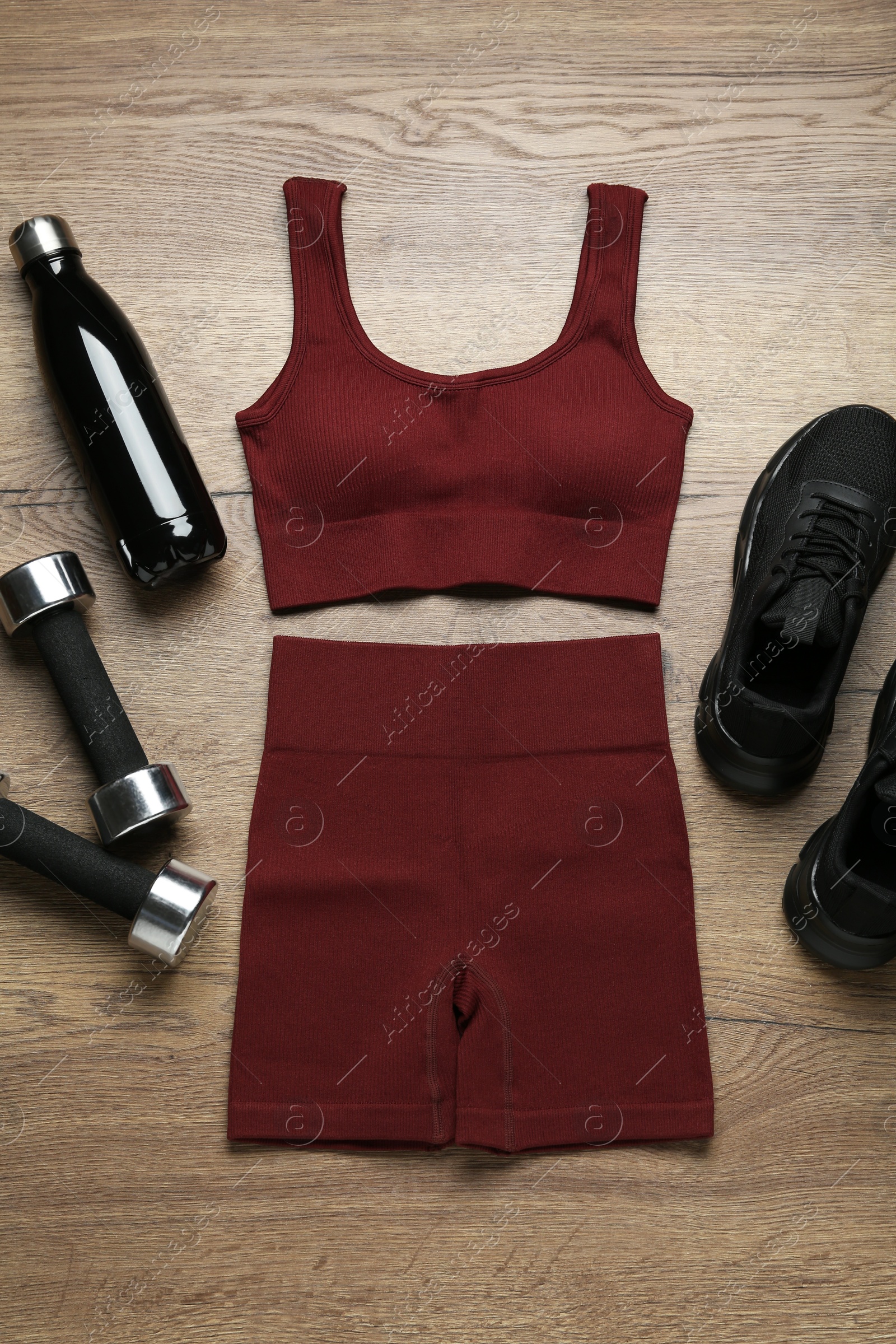 Photo of Flat lay composition with women's sportswear and sneakers on wooden background