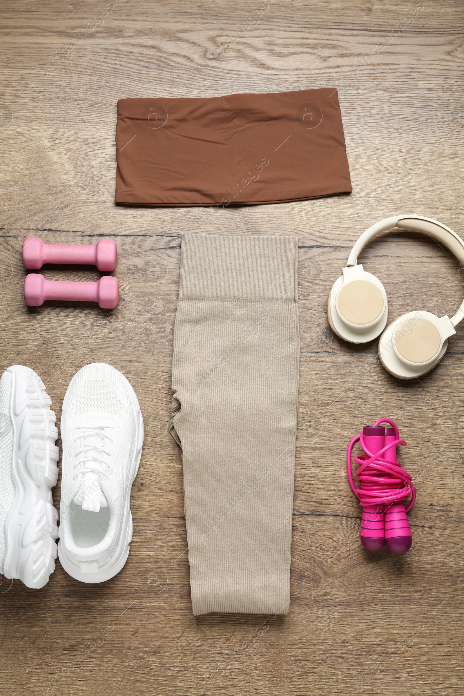 Photo of Flat lay composition with women's sportswear and athletic equipment on wooden background