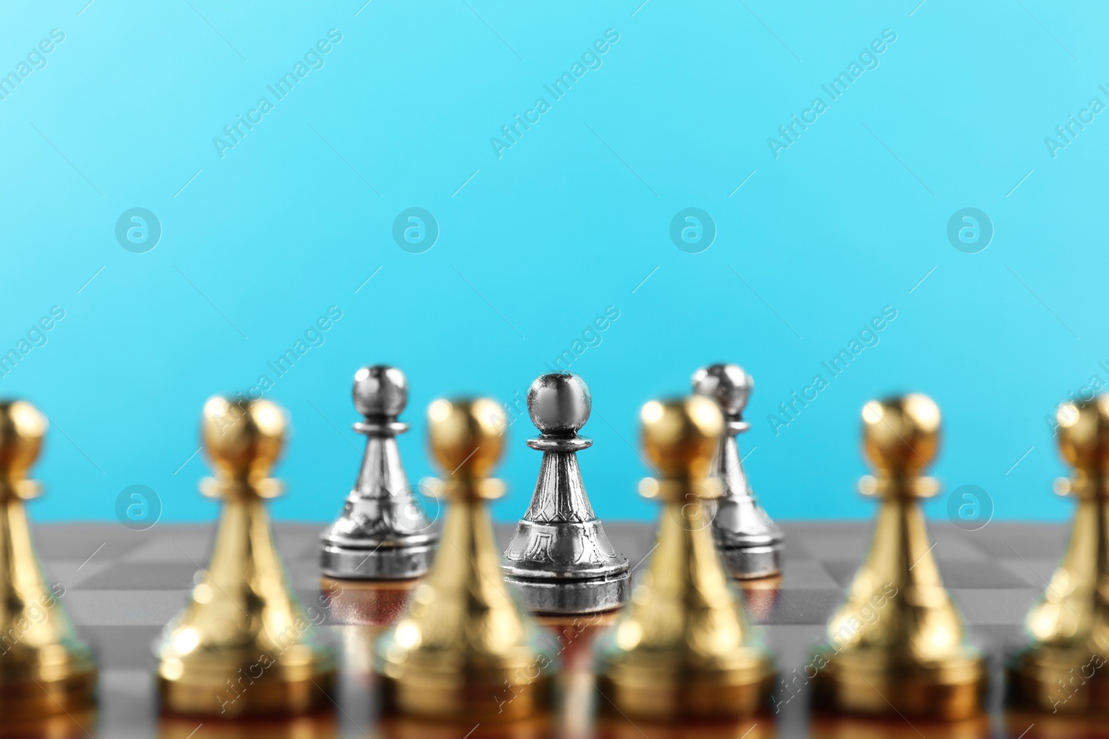 Photo of Silver pawns in front of other golden ones on chessboard. Competition concept