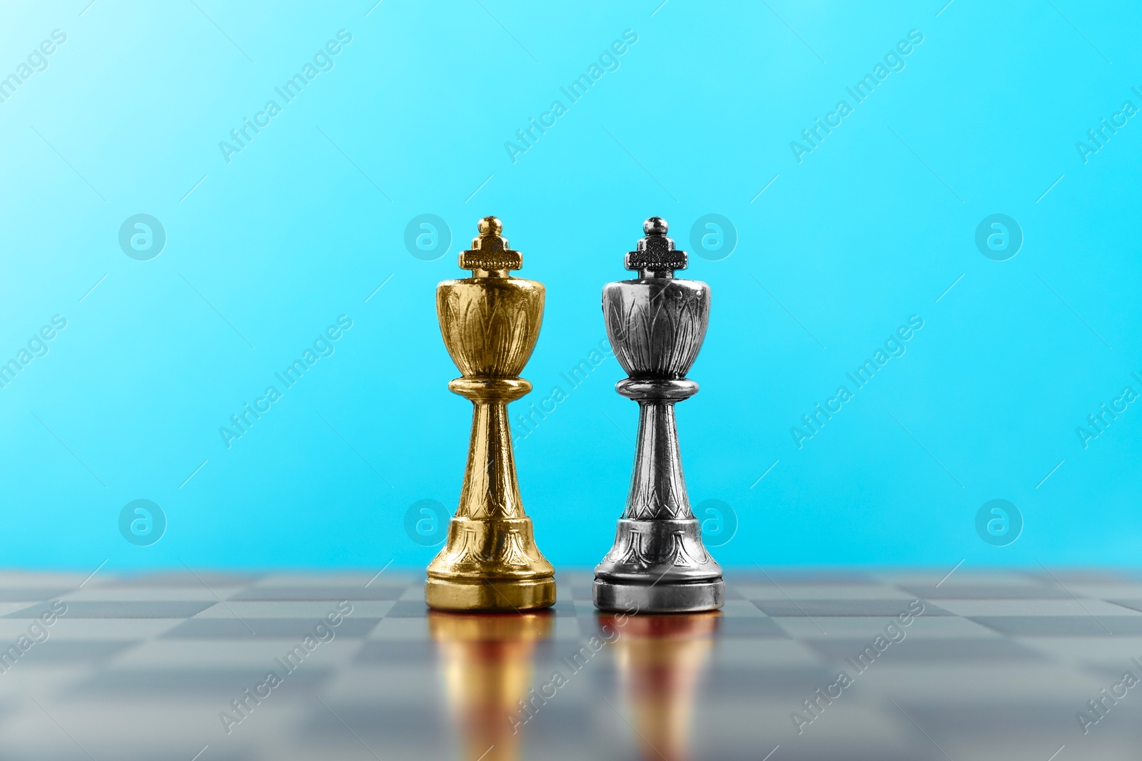 Photo of Golden and silver chess kings in middle of chessboard. Competition concept